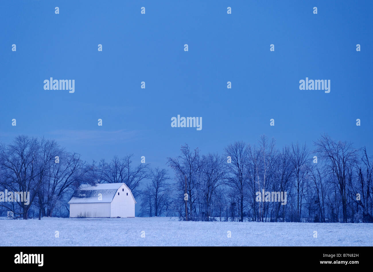 Weiße Scheune im Schnee in der Abenddämmerung in Crawford County Indiana Stockfoto