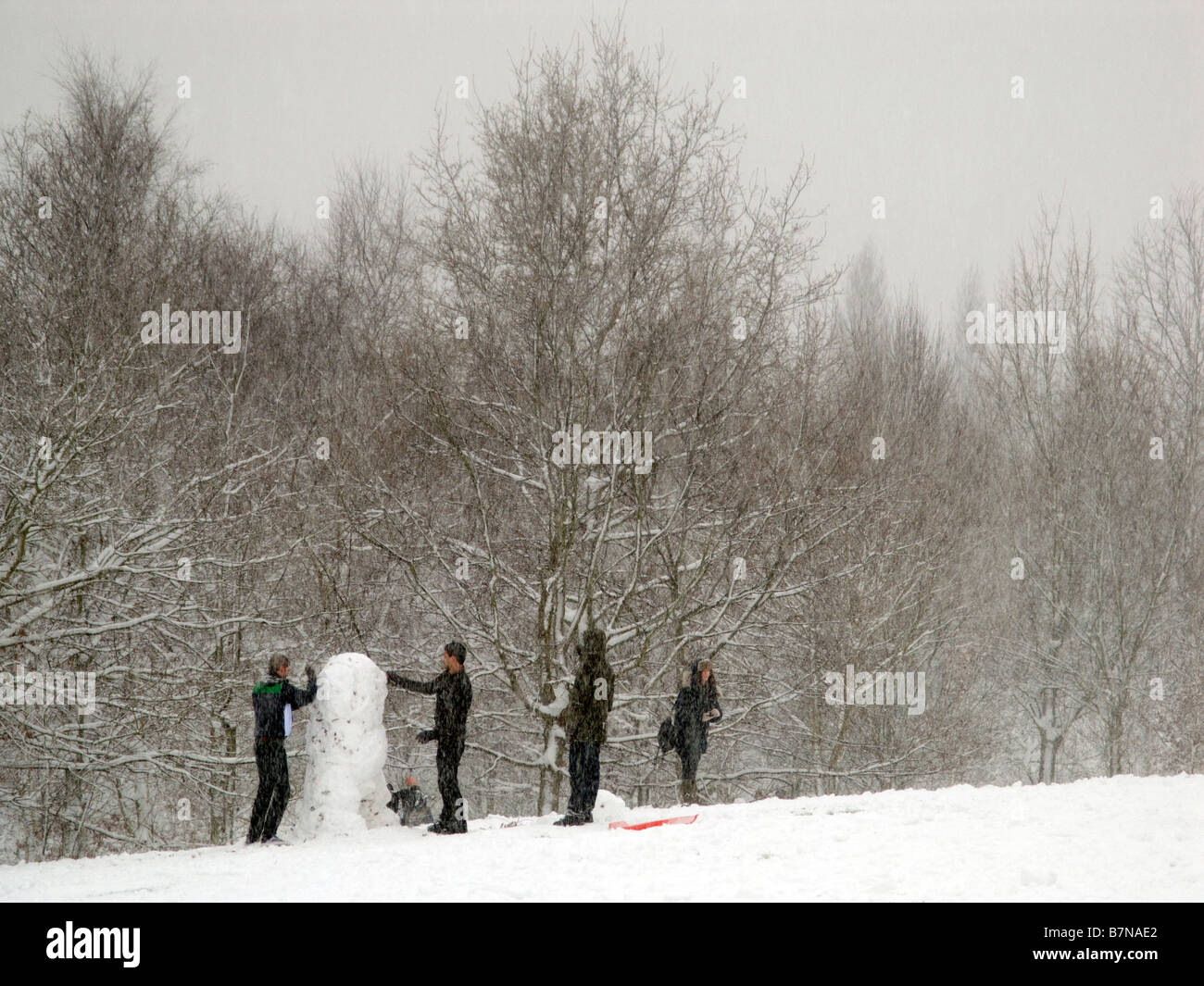 Jugendliche einen Schneemann bauen. Stockfoto