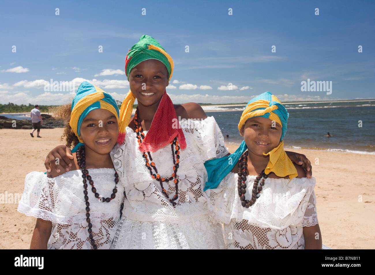 Junge brasilianische Mutter mit jungen Töchter tragen weiße Kleider mit bunten Kopf-Kleider am Strand in Brasilien Stockfoto
