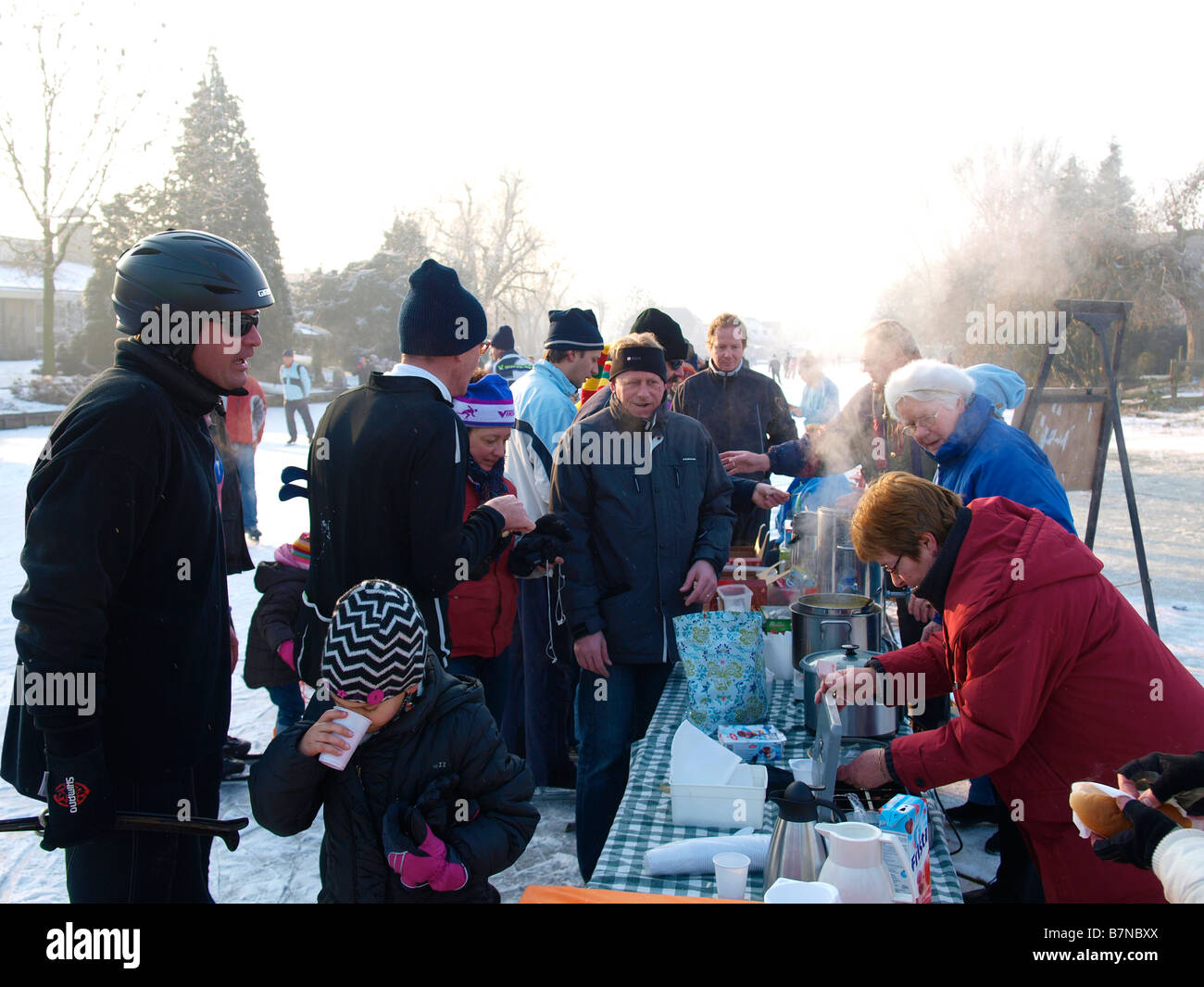Leute verkaufen heiße Getränke und Suppe, müde Skater auf dem Eis während der Molentocht Windmühle Tour Oud Alblas Niederlande Stockfoto