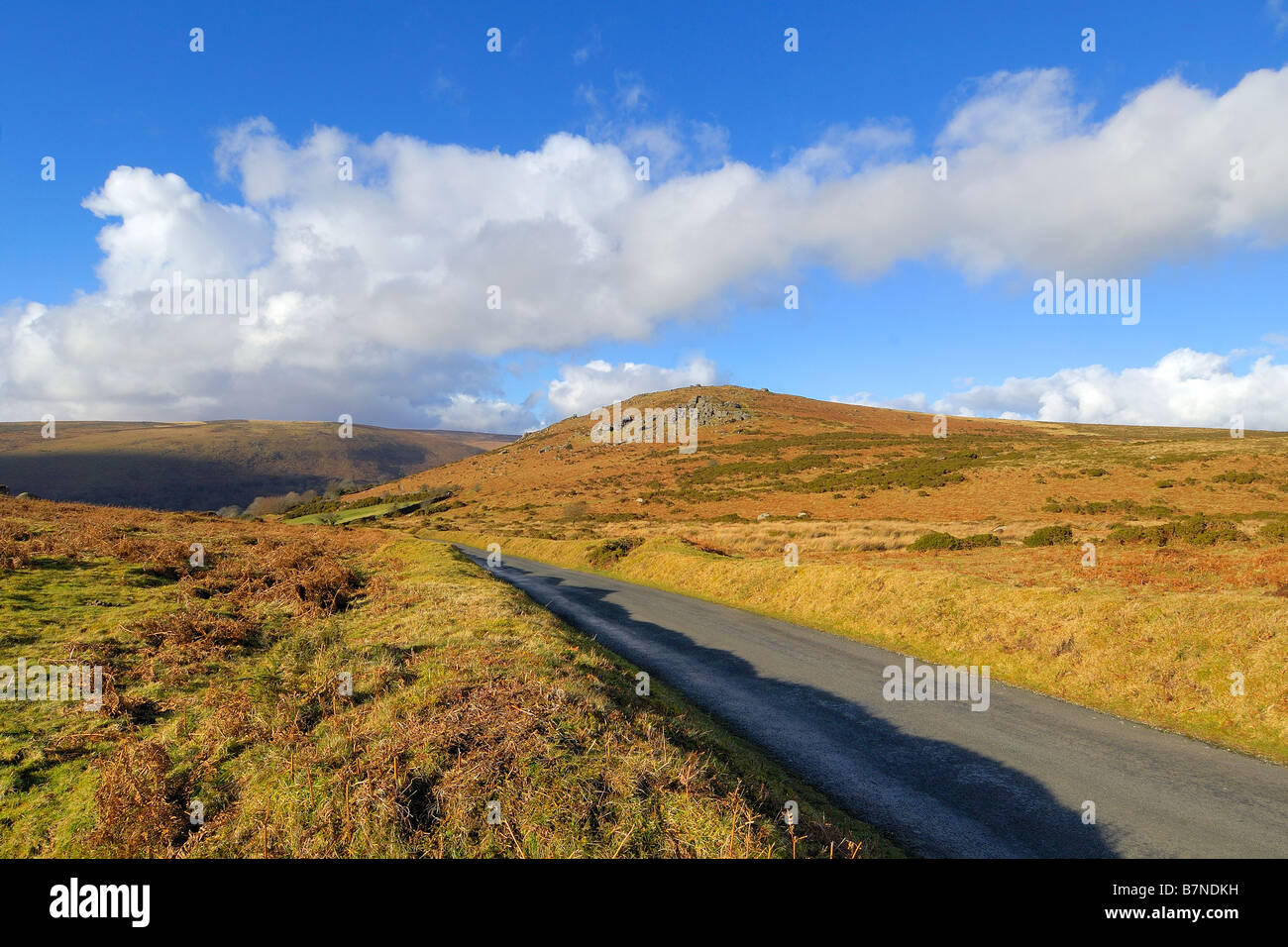 Einer schmalen einspurigen Landstraße in der Nähe von Bonehill Felsen auf Dartmoor mit Chinkwell Tor im Mittelgrund Stockfoto