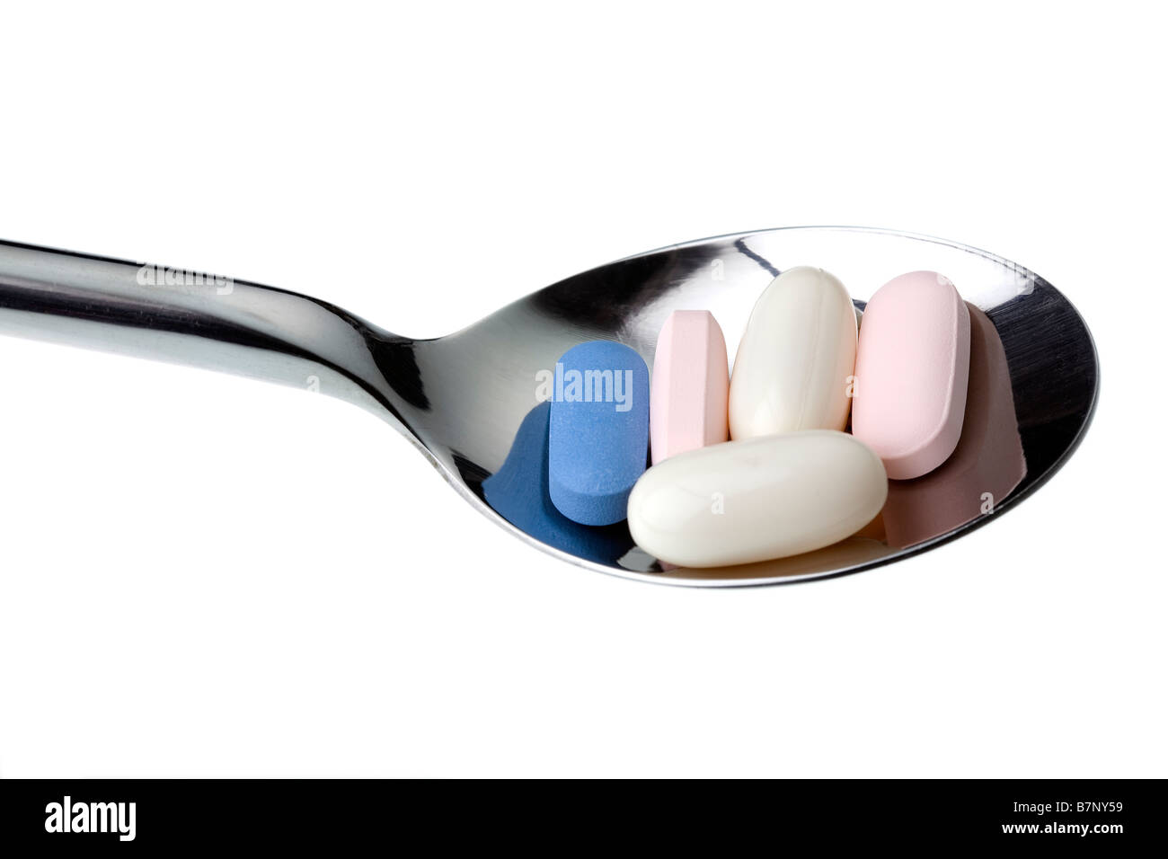 Mehrere Medikamente Pillen auf einem Löffel auf weißen Hintergrund isoliert das ist die tägliche Dosis von einem ein Inhibitor-Kurs für HIV Stockfoto