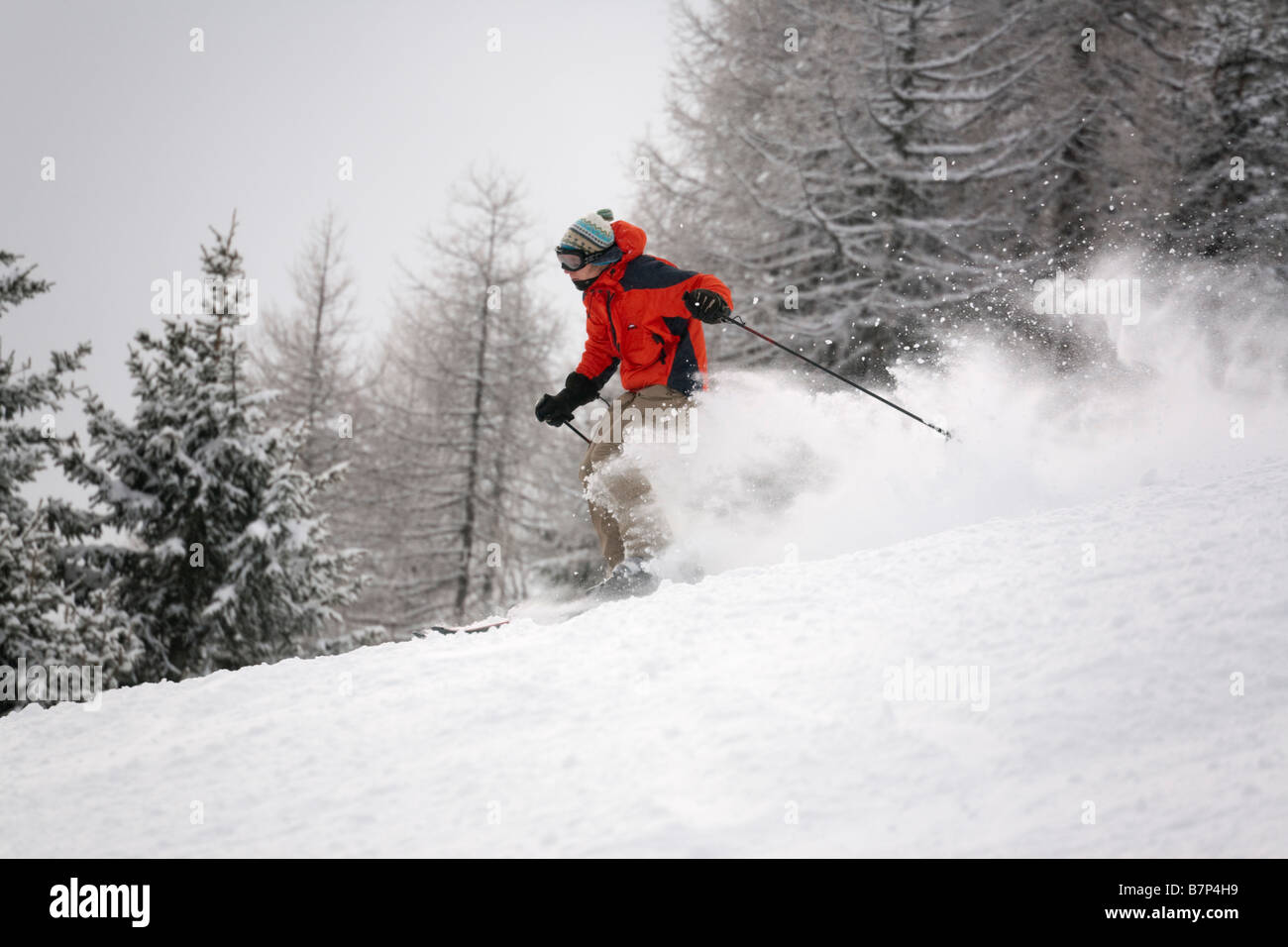 Skifahrer trägt eine rote Jacke Ski schnelle Abfahrt im Pulverschnee auf der Piste Piste in den österreichischen Alpen. Rauris, Österreich Stockfoto