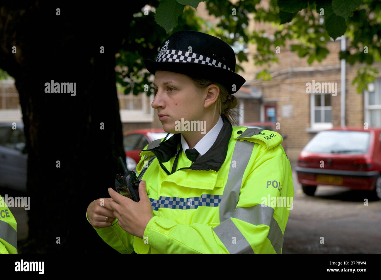 Eine Frau Polizeibeamter bereitet ihr Radio nach einer Informationsveranstaltung vor dem diensthabenden Watford Stadium Stockfoto