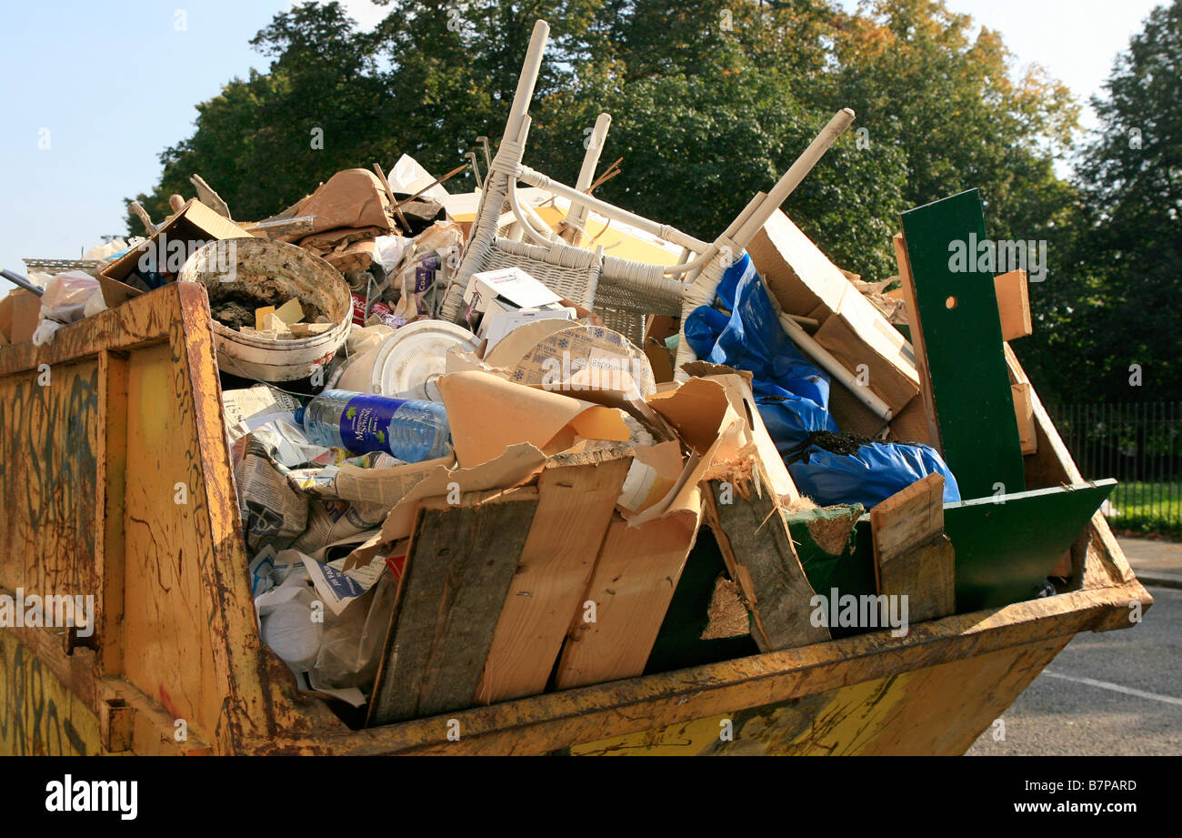 GV eine gelbe Skip voller Müll. Stockfoto