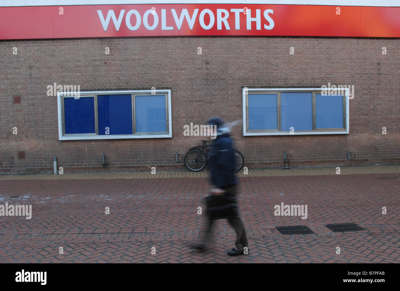 Ein Mann geht vorbei an einem stillgelegten Zweig eines Woolworths Shop in Chelsmford, Essex, kurz nachdem sie in die Verwaltung ging. Stockfoto