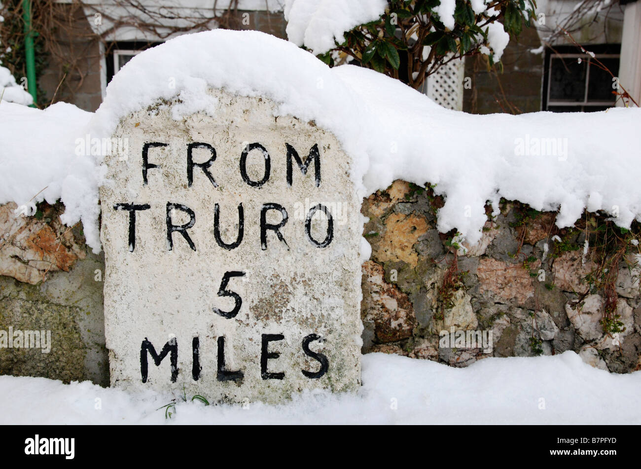 eine schneebedeckte Meilenstein zeigt 5 Meilen, Truro, Cornwall, uk Stockfoto