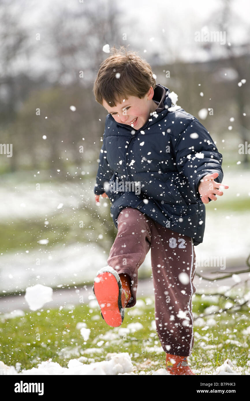 Junge glücklich Kick treten Kid Schnee Flocken Winter Stockfoto