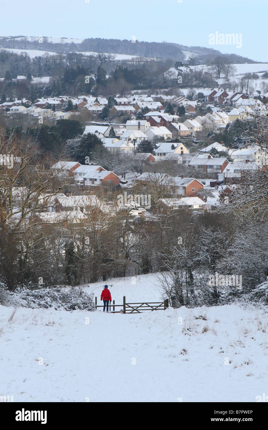 Frau, die im Januar 2009 in tiefem Winterschnee auf einem Hügel mit Blick auf die Stadt Wells Somerset spaziert Stockfoto