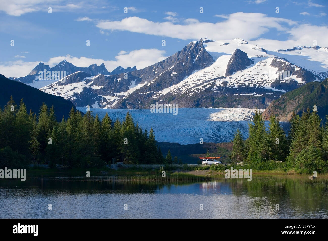 Fahrzeug fährt Mendenhall Loop Road w/Mendenhall Gletscher im Hintergrund Juneau Alaska Sommer Stockfoto