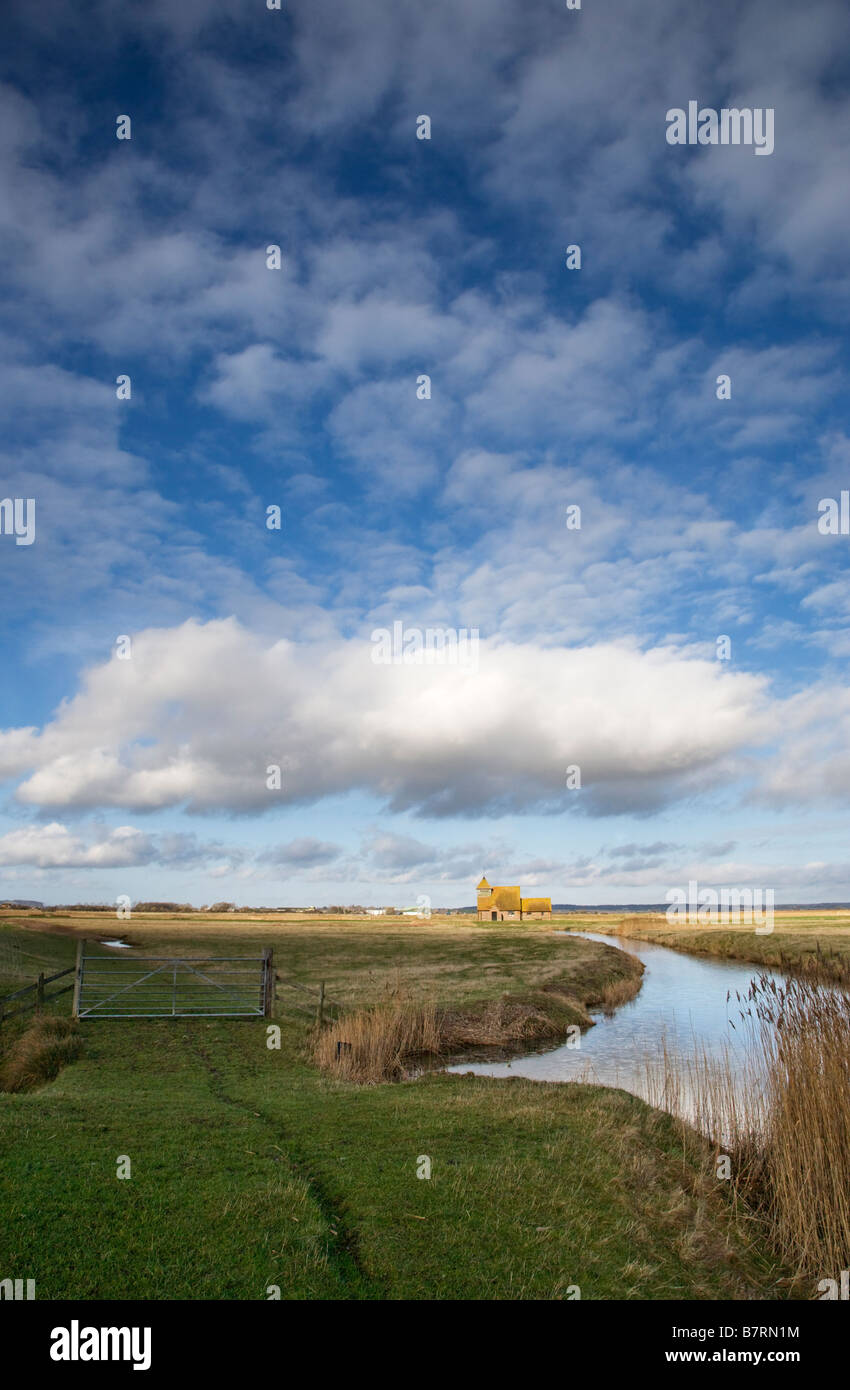 Wolkenformation über eine Romney Marsh Kent Landschaft mit Hl. Thomas Becket Kirche in der Ferne. Stockfoto