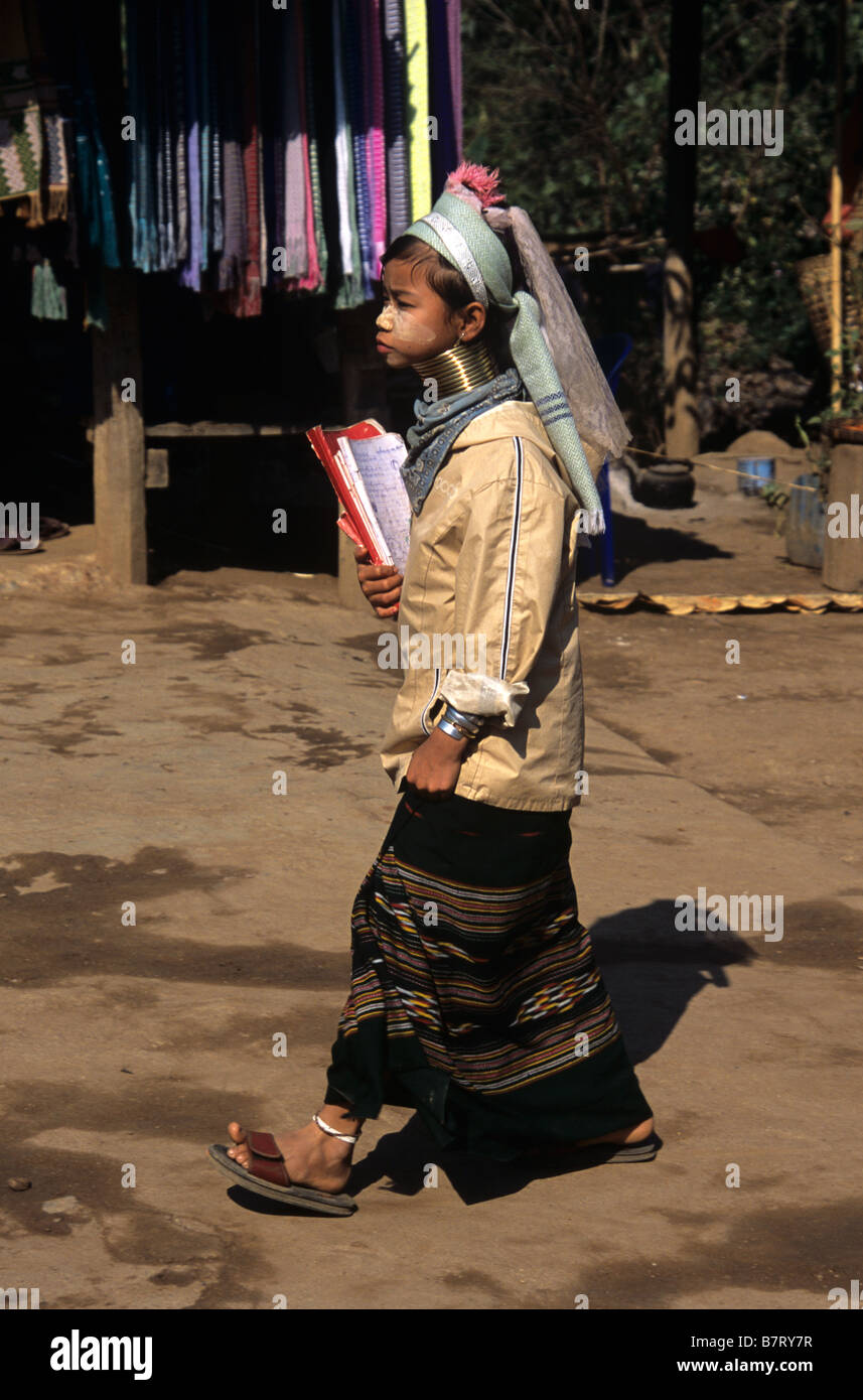 Eine burmesische Padaung lang-necked Mädchen zu Fuß zur Schule mit Büchern, im Flüchtlingslager, Mae Hong Son Provinz, Thailand Stockfoto