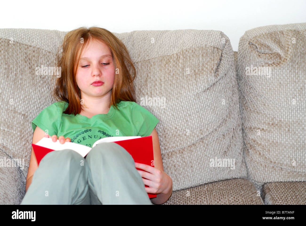 Junges Mädchen ein Buch auf der couch Stockfoto