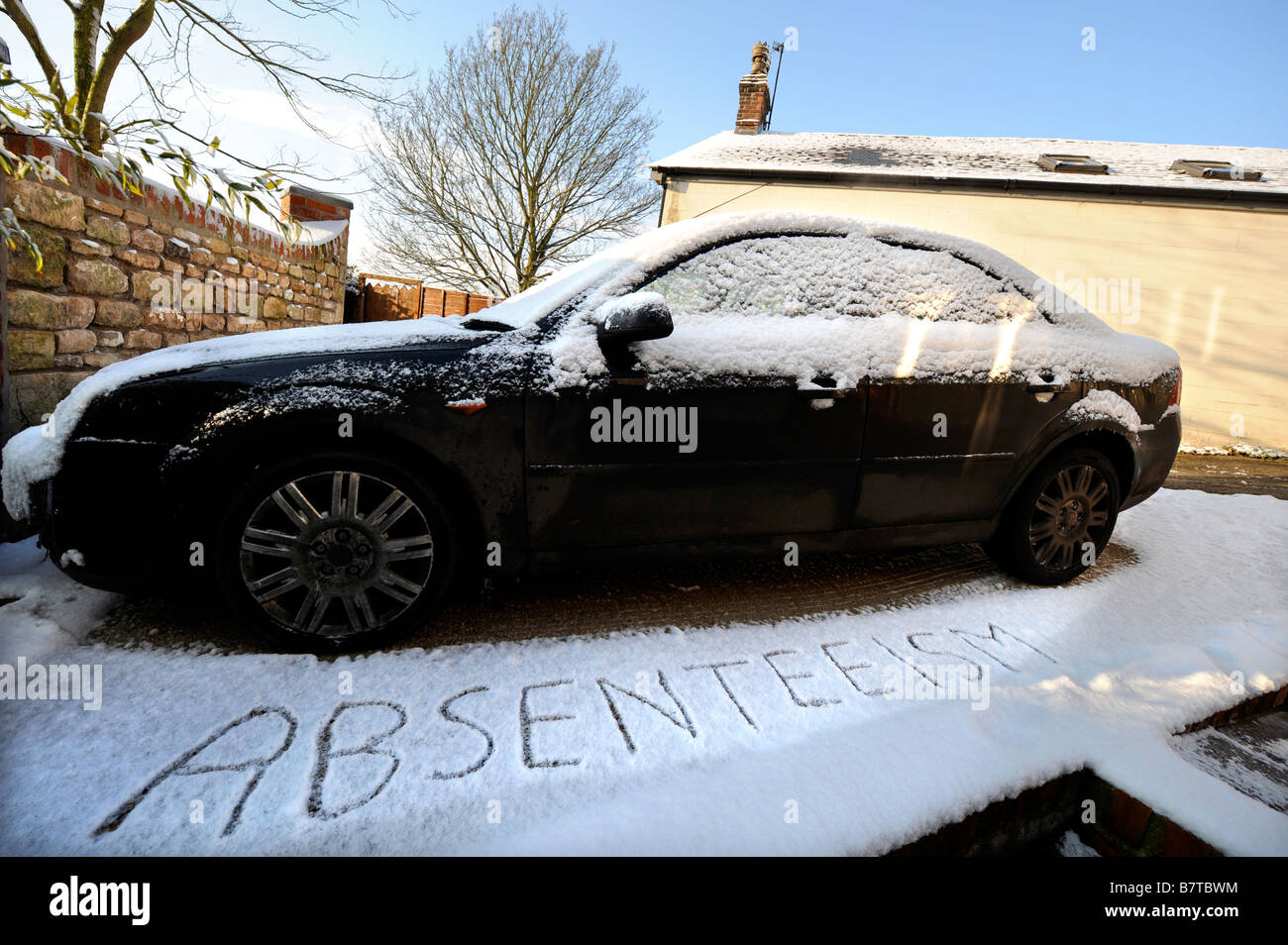 AUTO AUF EINER EINFAHRT MIT WORTEN ZUBEREITER GESCHRIEBEN SCHNEE VORGESCHLAGEN ABWESENHEIT VON DER ARBEIT BEI MODERATEN WINTERLICHEN BEDINGUNGEN U Stockfoto