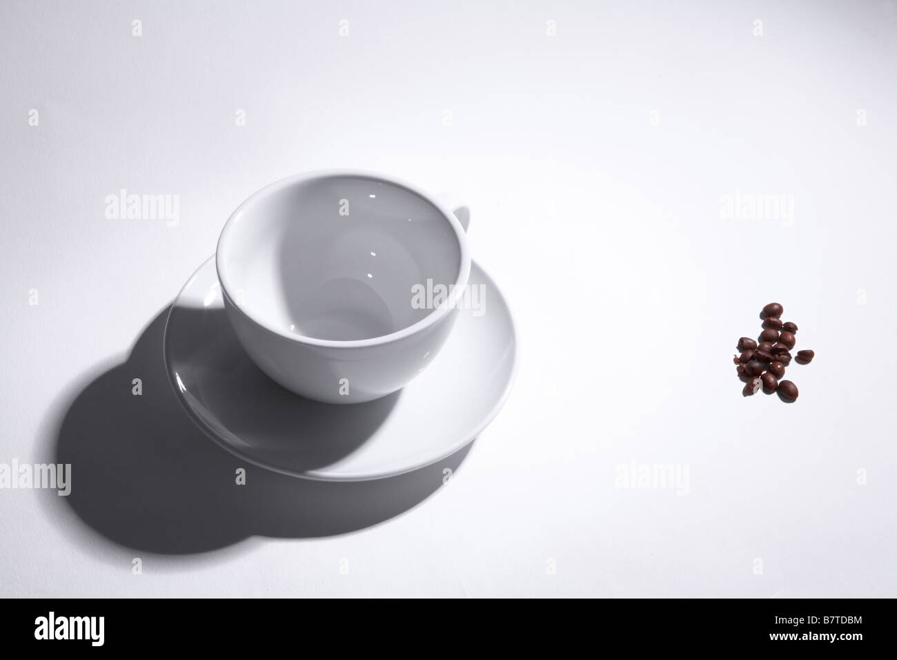 Leere Tasse auf weißem Hintergrund. Kaffeebohnen an der Seite. Stockfoto