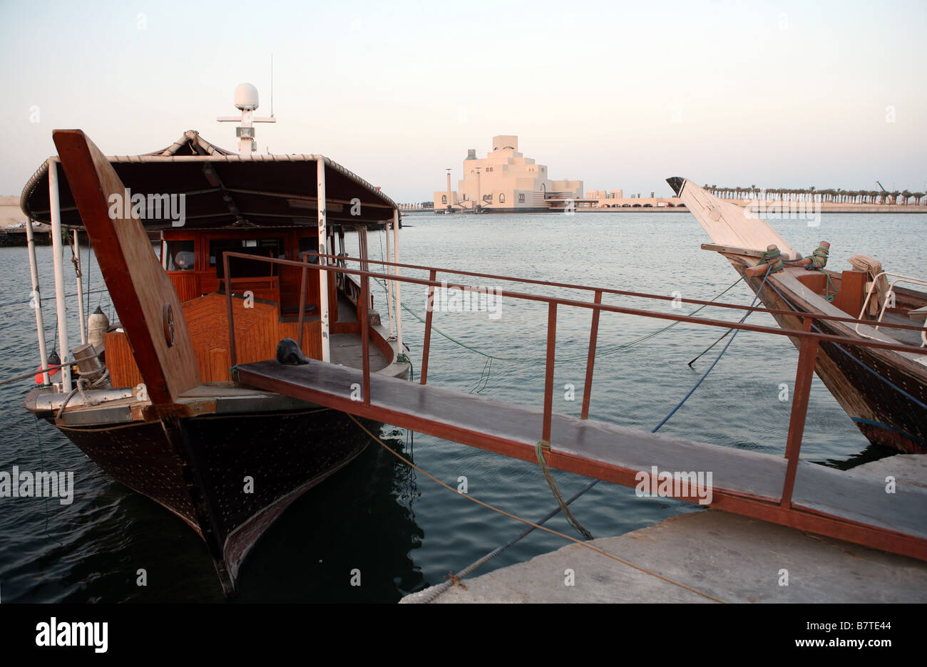 Arabischen Dhaus gefesselt im Hafen von Doha mit Qatar s Museum für islamische Kunst im Hintergrund Stockfoto