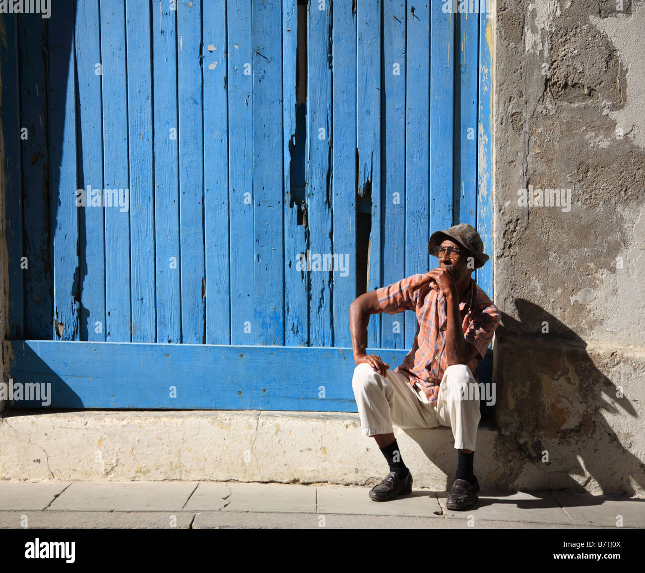 Kubanische Mann und seine Zigarre setzte sich auf einen Schritt in den Straßen von Havanna in Kuba Stockfoto
