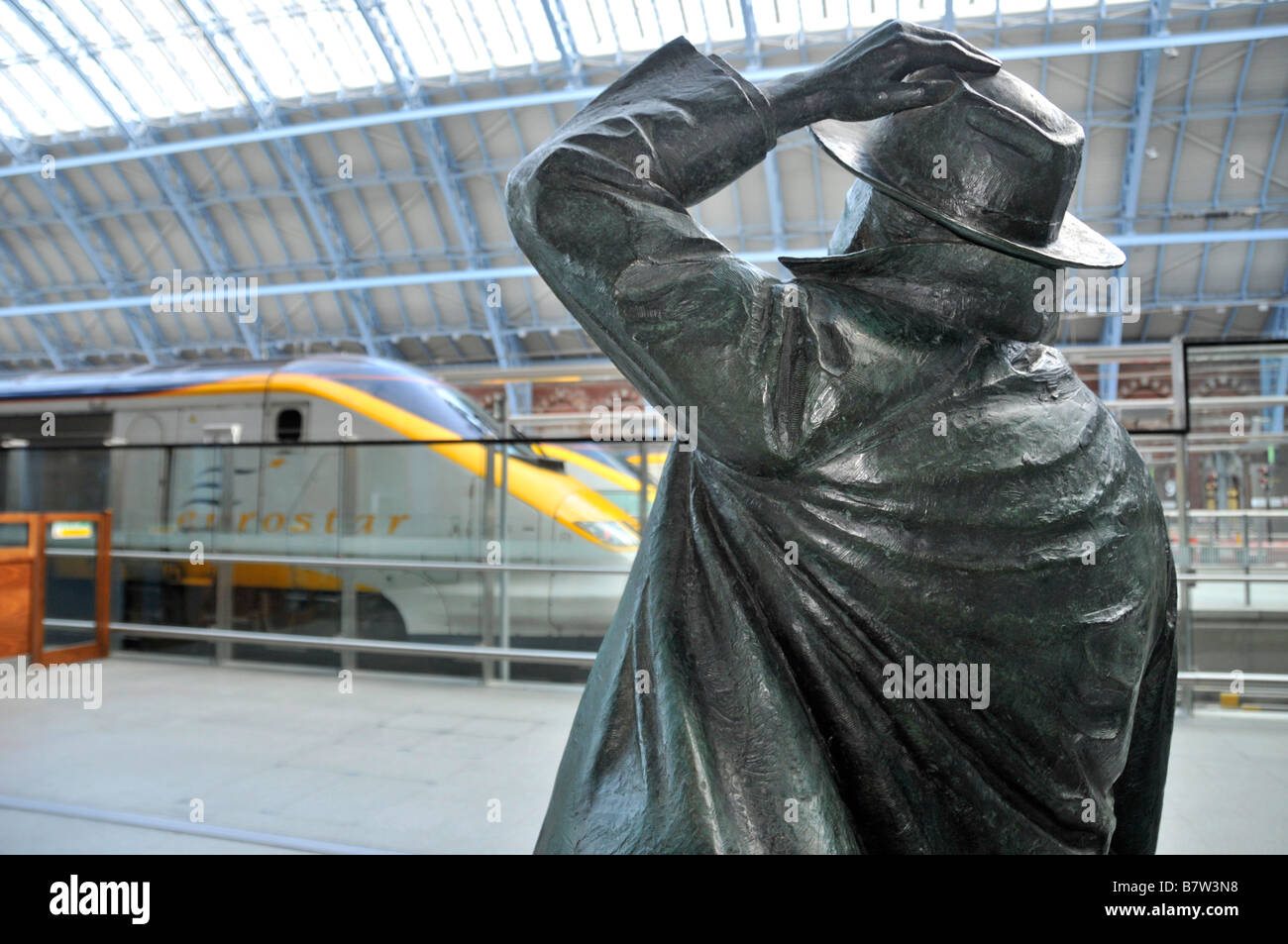 St Pancras International Railway Bahnhofshalle zurück aus Bronze Statue von Sir John Betjeman von Bildhauer Martin Jennings mit Eurostar über Stockfoto