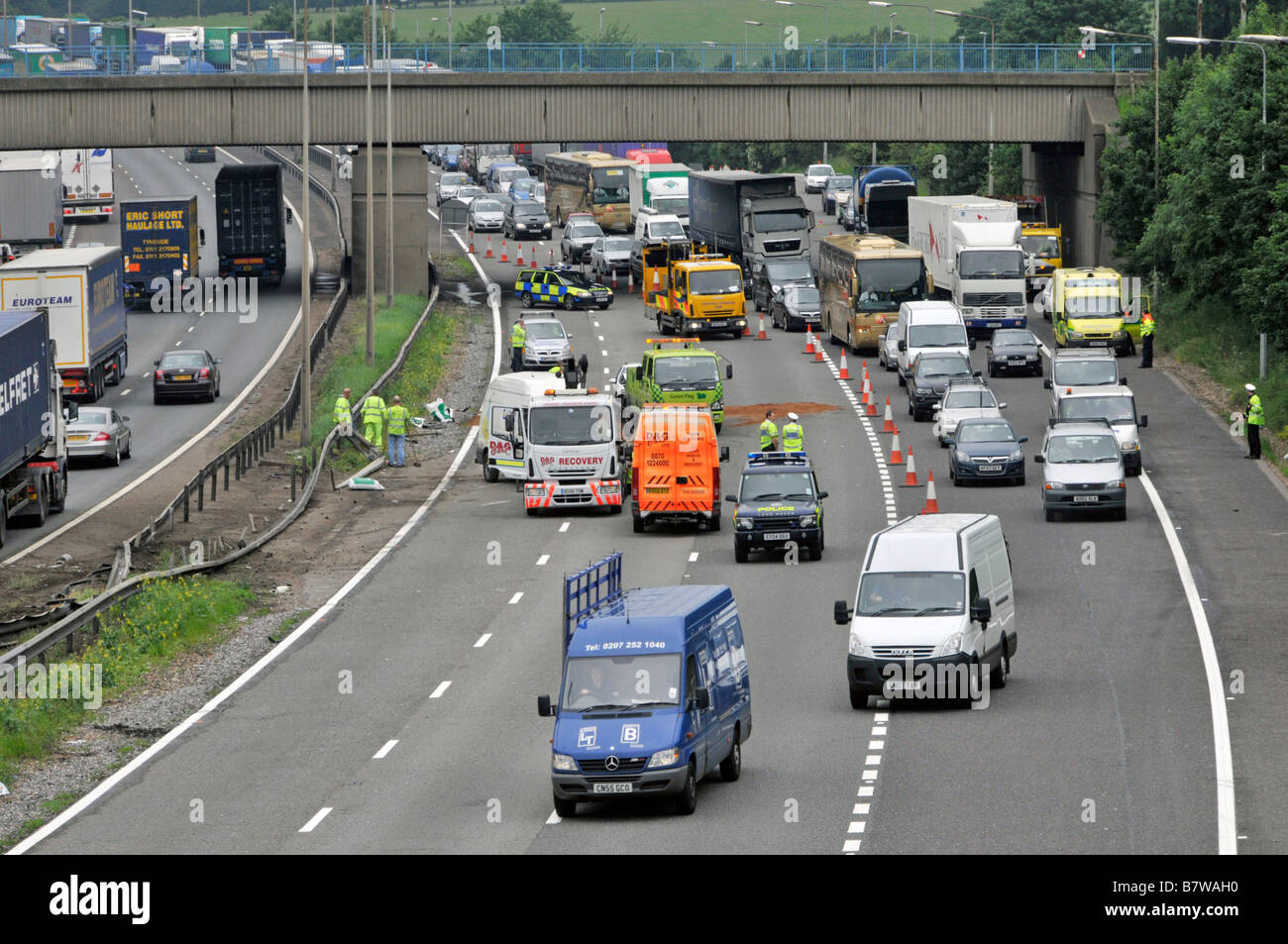 Luftaufnahme M25 Autobahn Schlange von verzögerten langsam fahrenden Auto LKW-Verkehr vorbei Straßenverkehr Unfall mit Polizei & Recovery-Fahrzeuge England Stockfoto