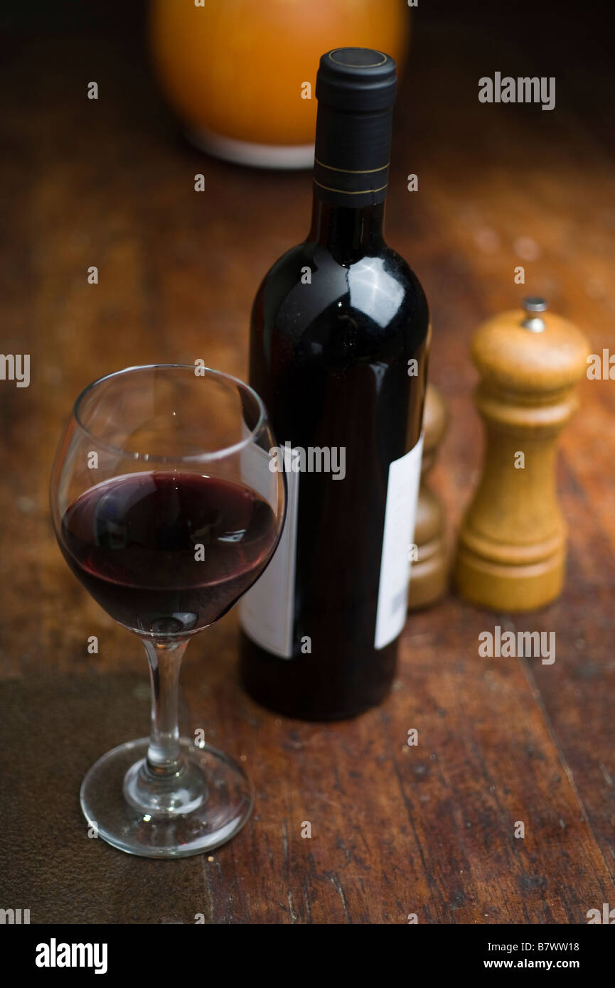 Stimmungsvolle Bild eines Glas und Flasche Rotwein die Flasche hat keine Logos oder Marken und ist sicher für kommerzielle Nutzung Stockfoto