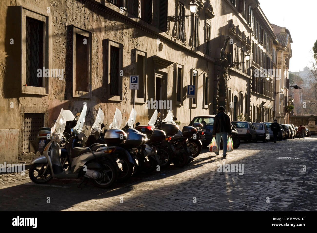 Tief stehender Sonne scheint auf einer Straße im historischen Zentrum von Rom, Italien Stockfoto