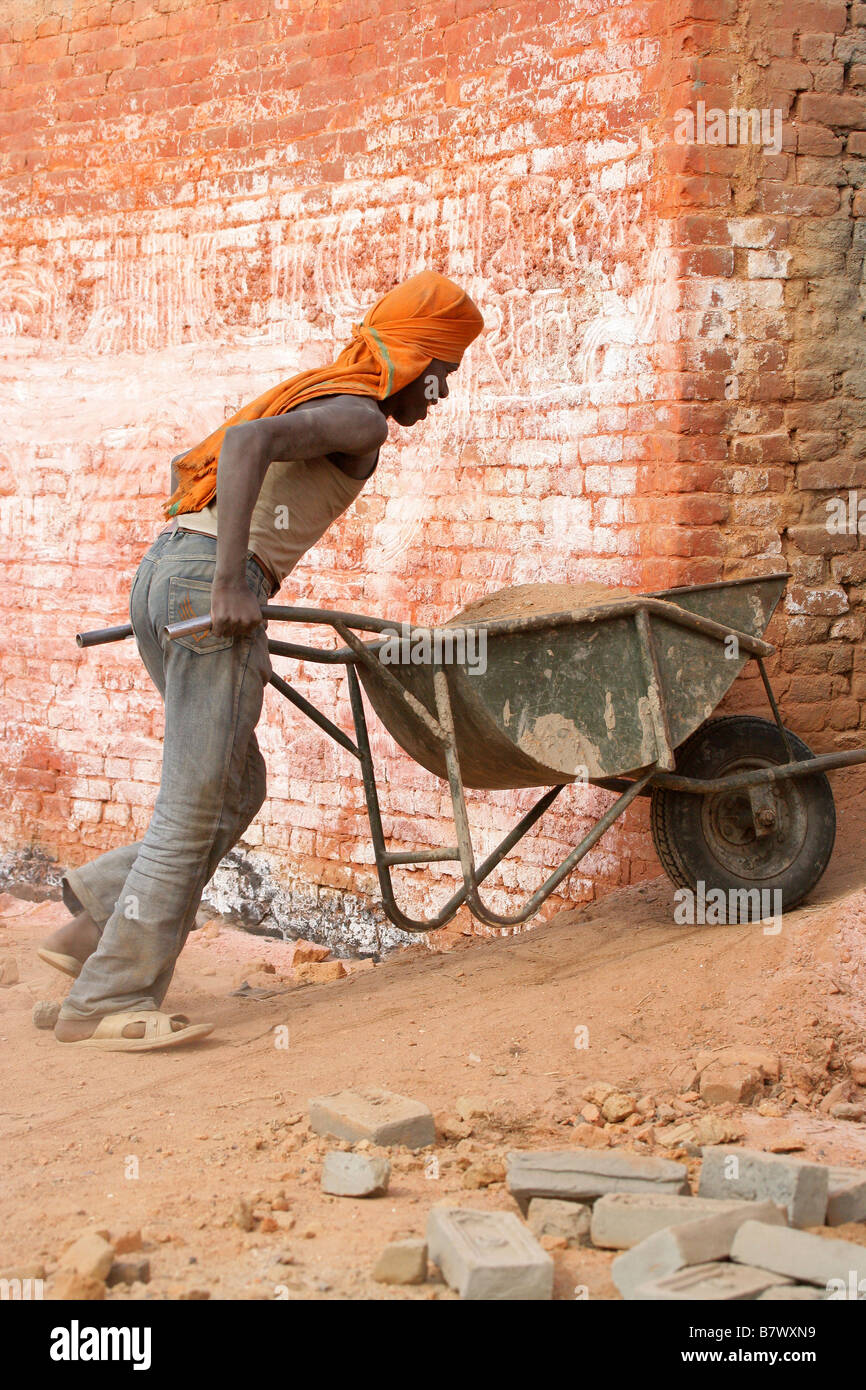 Indischer Junge treibt eine Rad Barrow nepalesischen Ziegelei Stockfoto