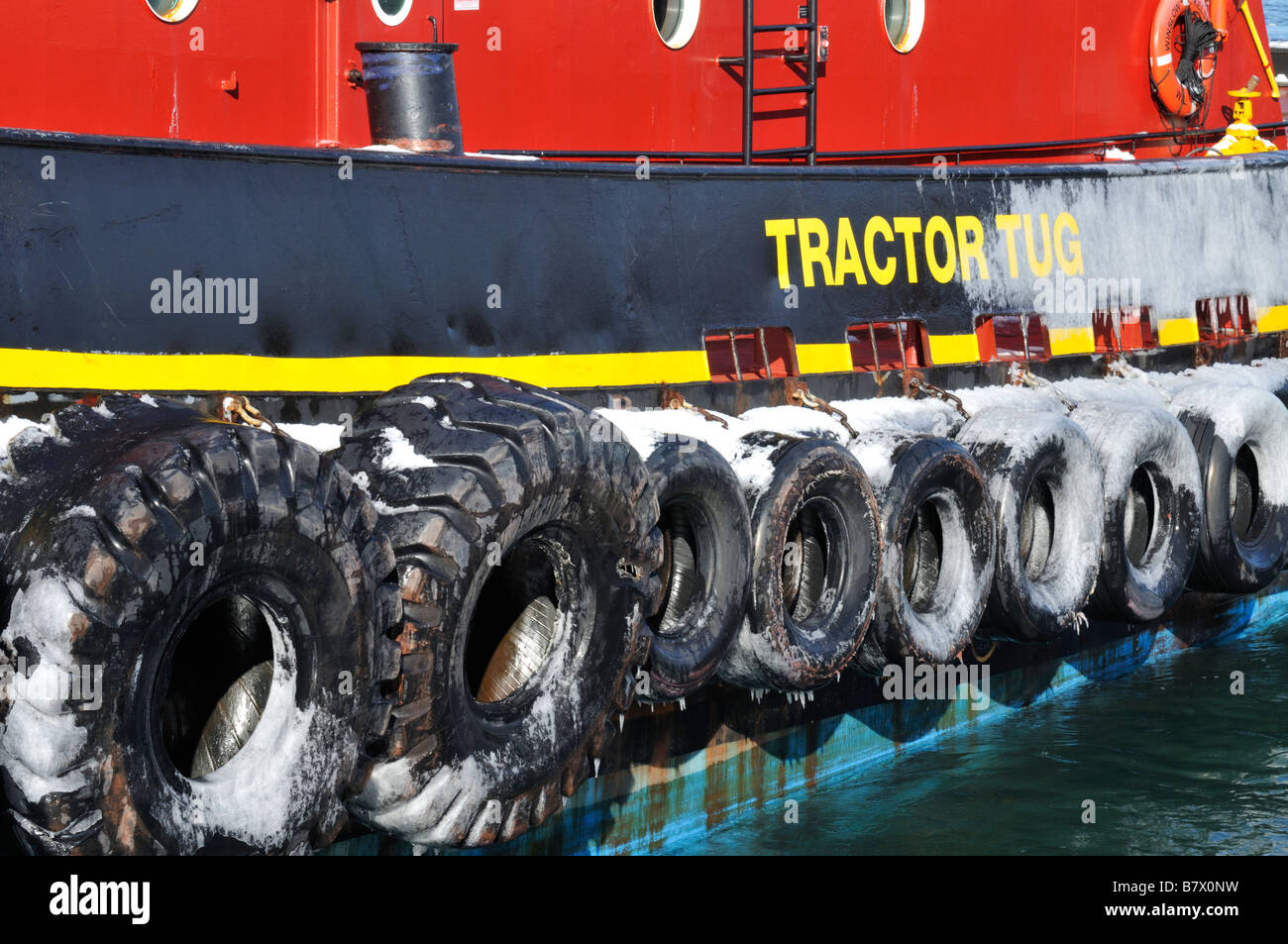 Traktor Schlepper Reifen auf Reling befestigt und hängen über Seite des Schleppers mit Eis gefroren darauf zeigen Stockfoto