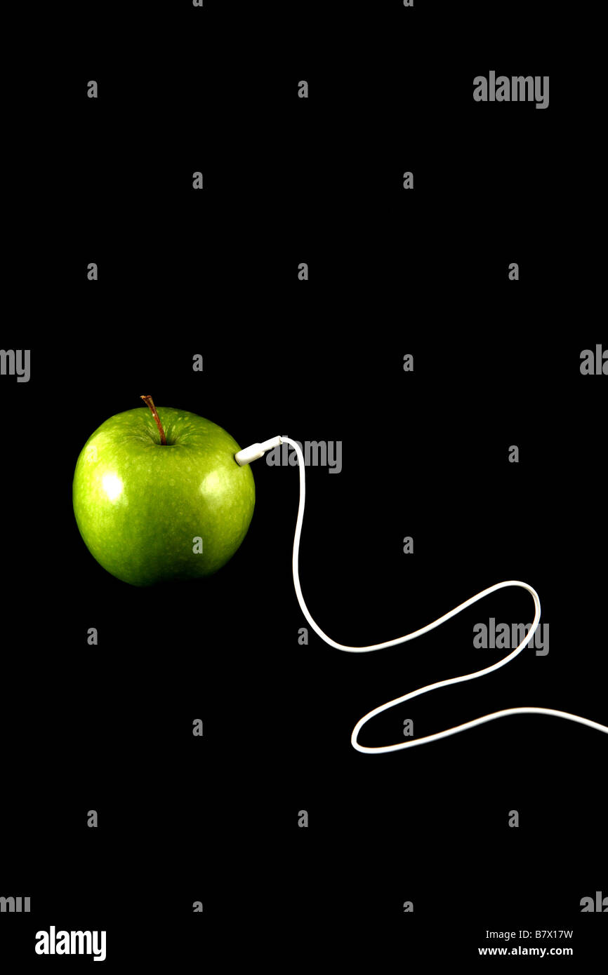 Apfel mit einem weißen Kopfhörerkabel Stockfoto