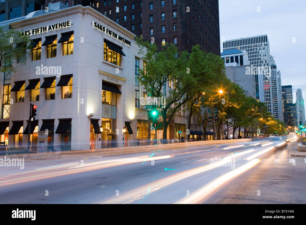 ILLINOIS-Chicago-Verkehr verschwommen in der Abenddämmerung, die Saks Fifth Avenue an der Michigan Avenue in der Abenddämmerung zu speichern Stockfoto