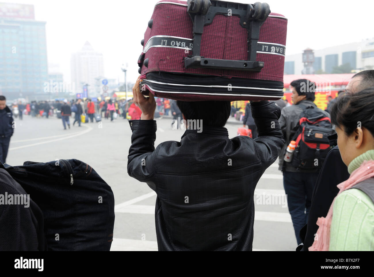 Migrantische ArbeiterInnen tragen ihr Gepäck vom Bahnhof in Nanchang, Jiangxi, China zu verlassen. 5. Februar 2009 Stockfoto