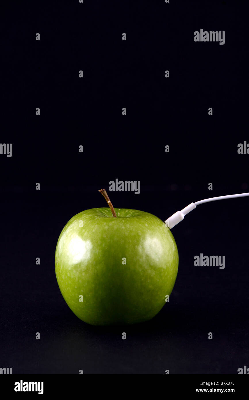 Ein grüner Apfel mit Kopfhörern im studio Stockfoto