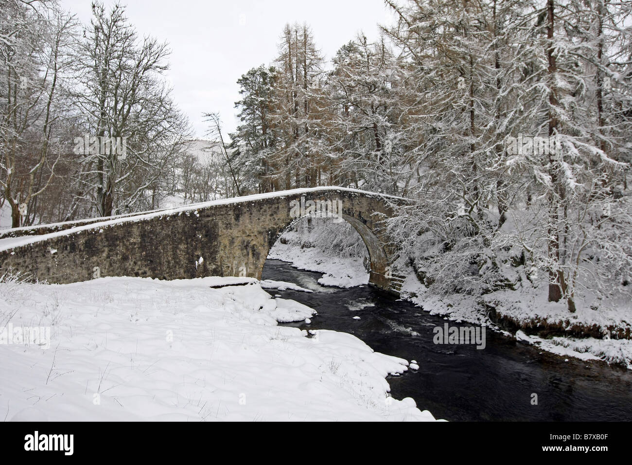 Alten Spannweite der Poldhullie Brücke über den Fluss Don in Strathdon, Aberdeenshire, Schottland, im Winter mit Schnee bedeckt. Stockfoto