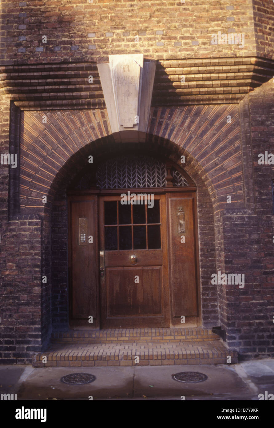 Arts And Crafts Stil Tür Eingang zur kleinen Wohnung block in Chelsea London mit Haustür und Schlussstein datiert 1911 Stockfoto