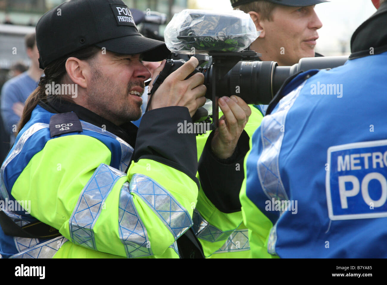 Ein Polizist überwacht, filmt und fotografiert einen Protest in London Stockfoto