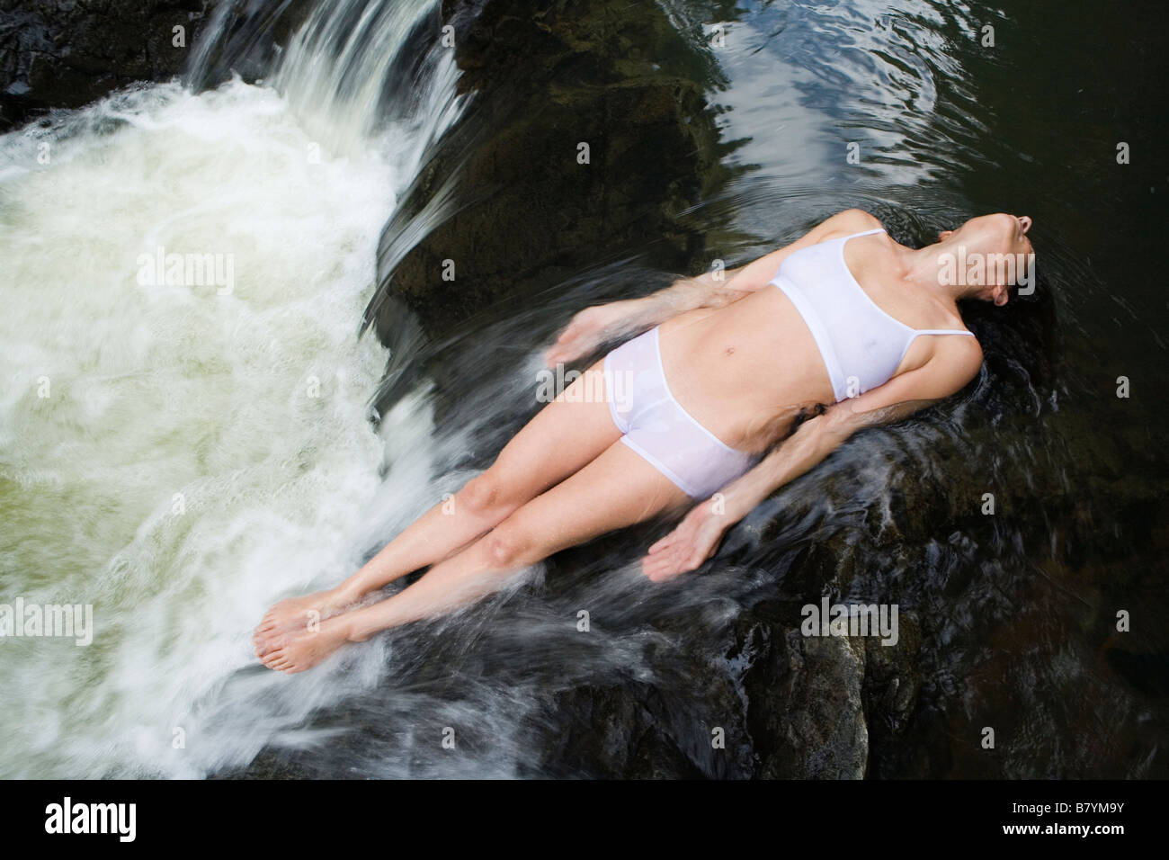 Frau im Wasserfall Stockfoto