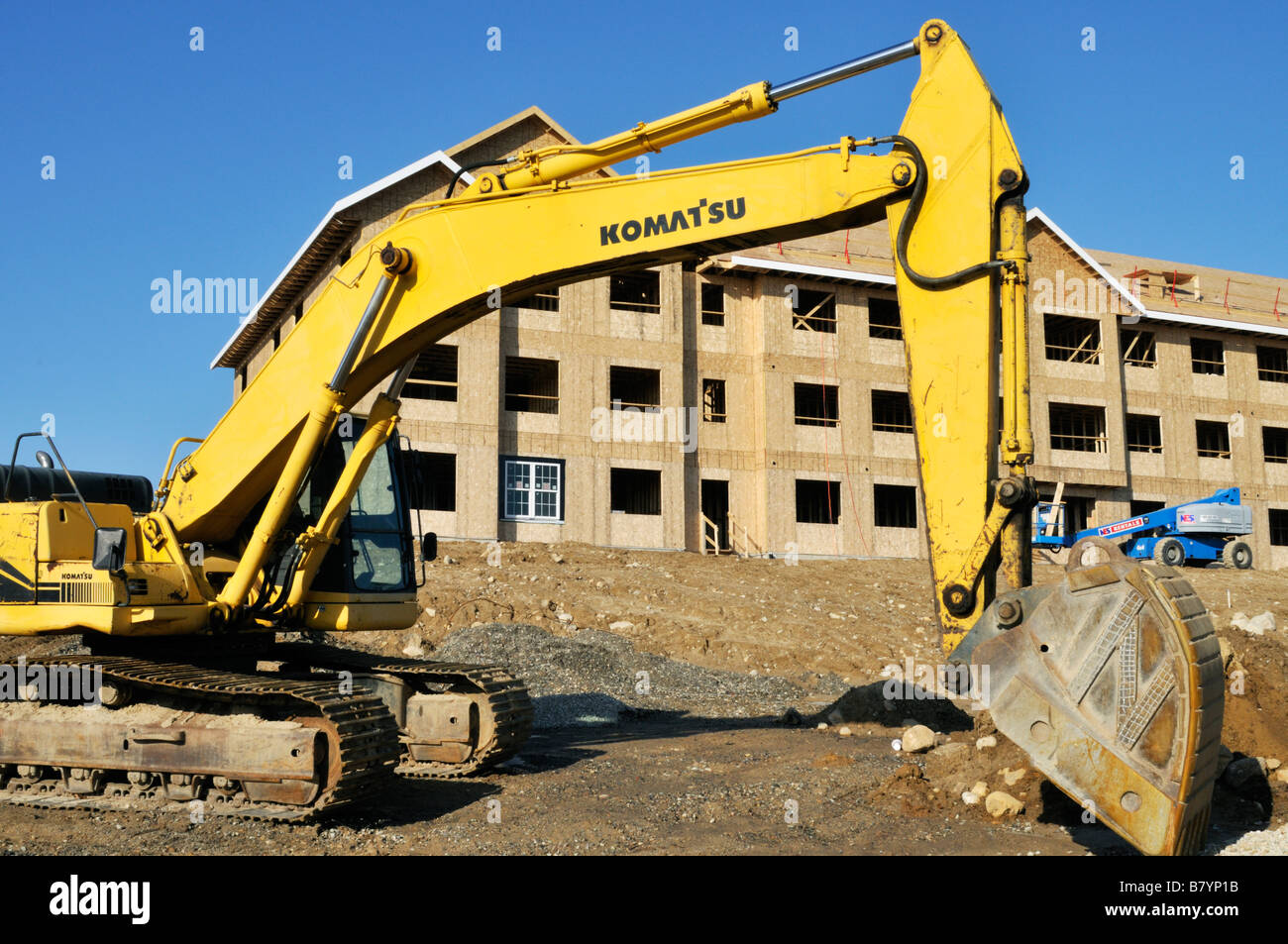 Komatsu zu verkaufen Gebrauchte Kettenbagger der Marke auf der Baustelle von einem Holzrahmen Apartment Gebäude Exterieur auf Cape Cod, Massachusetts, USA Stockfoto