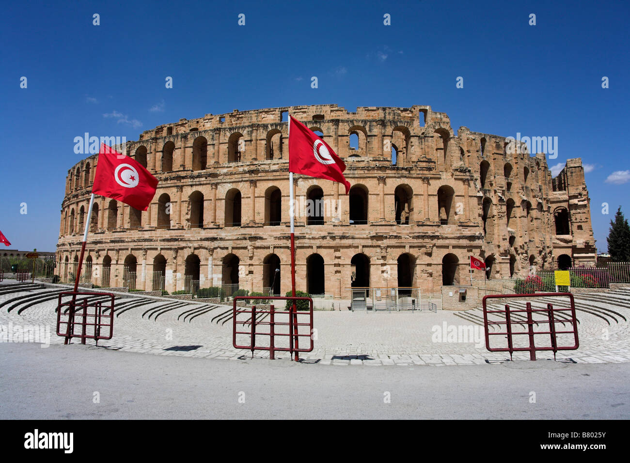 Eine tunesische Flagge vor dem römischen Amphitheater / Kolosseum. El Jem, Tunesien. Stockfoto