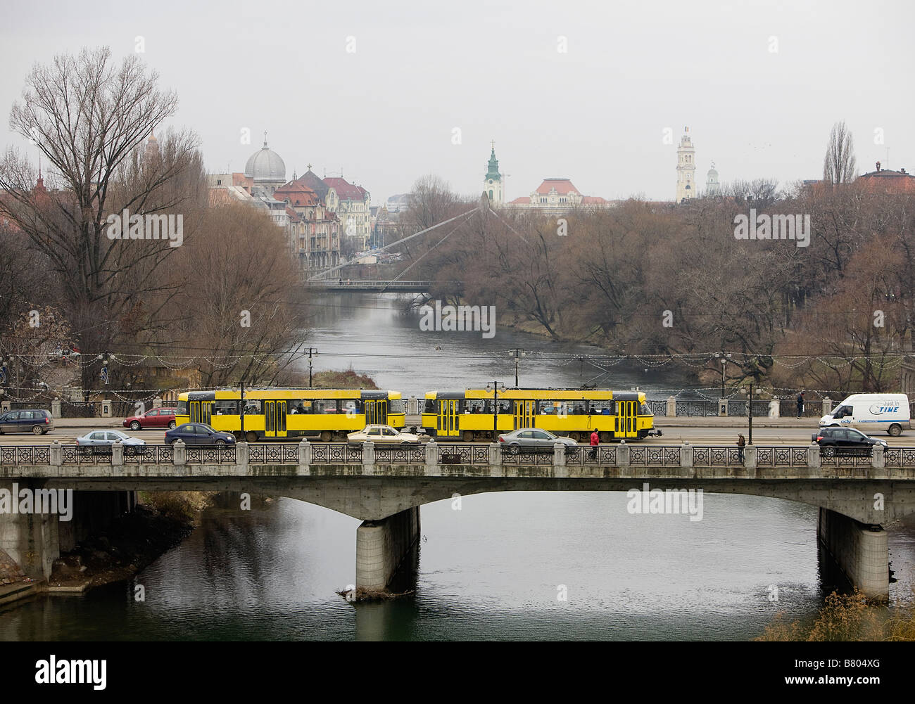 Eine Straßenbahn, die über eine Brücke über den Fluss Crisul Repede in der rumänischen Stadt Oradea in der Nähe der rumänischen Grenze mit Ungarn Stockfoto