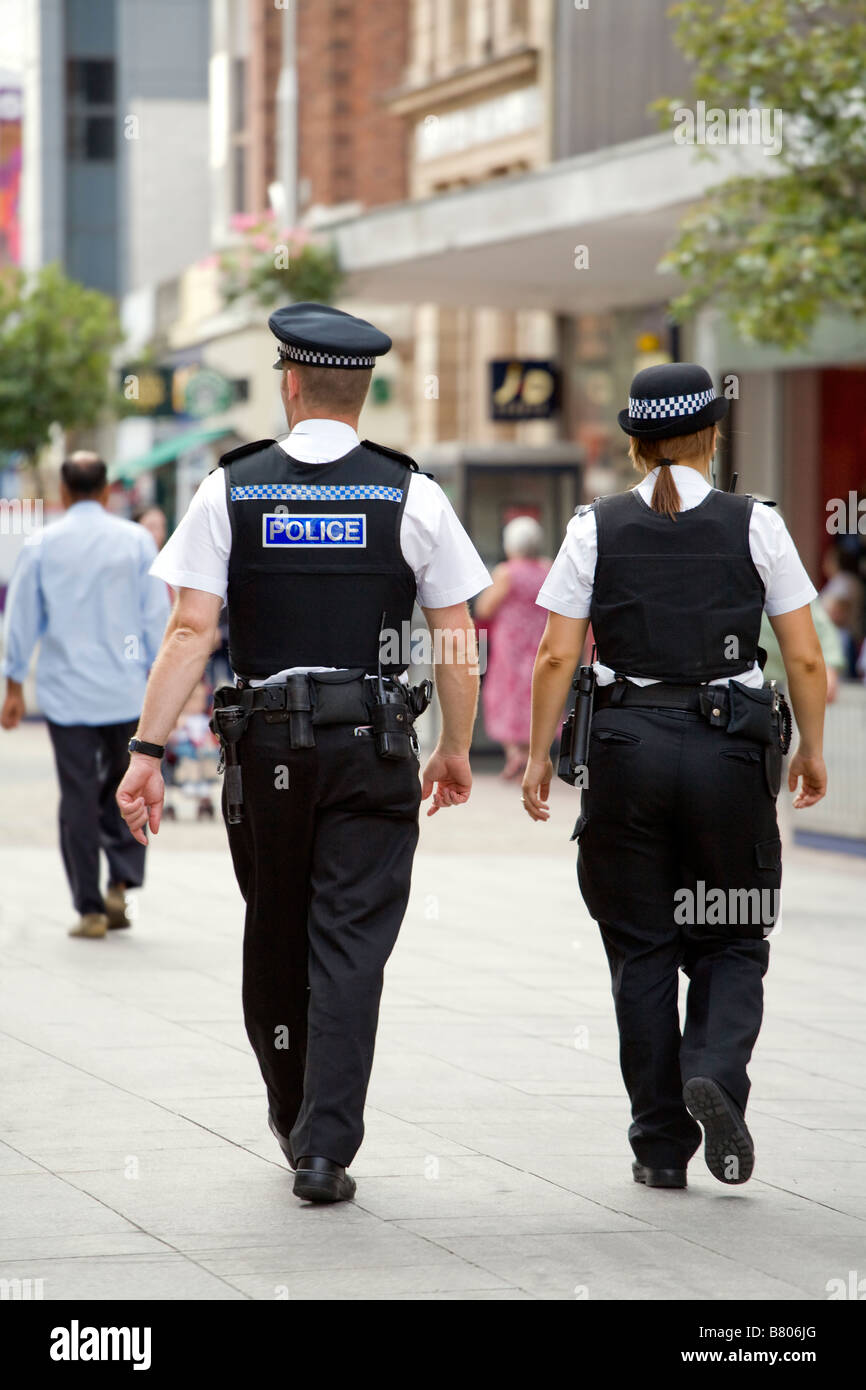 RÜCKSEITIGE ANSICHT VON ZWEI POLIZISTEN, MÄNNLICH UND WEIBLICH, AUF DER HOHEN STRAßE IN SOUTHEND ON SEA. Stockfoto