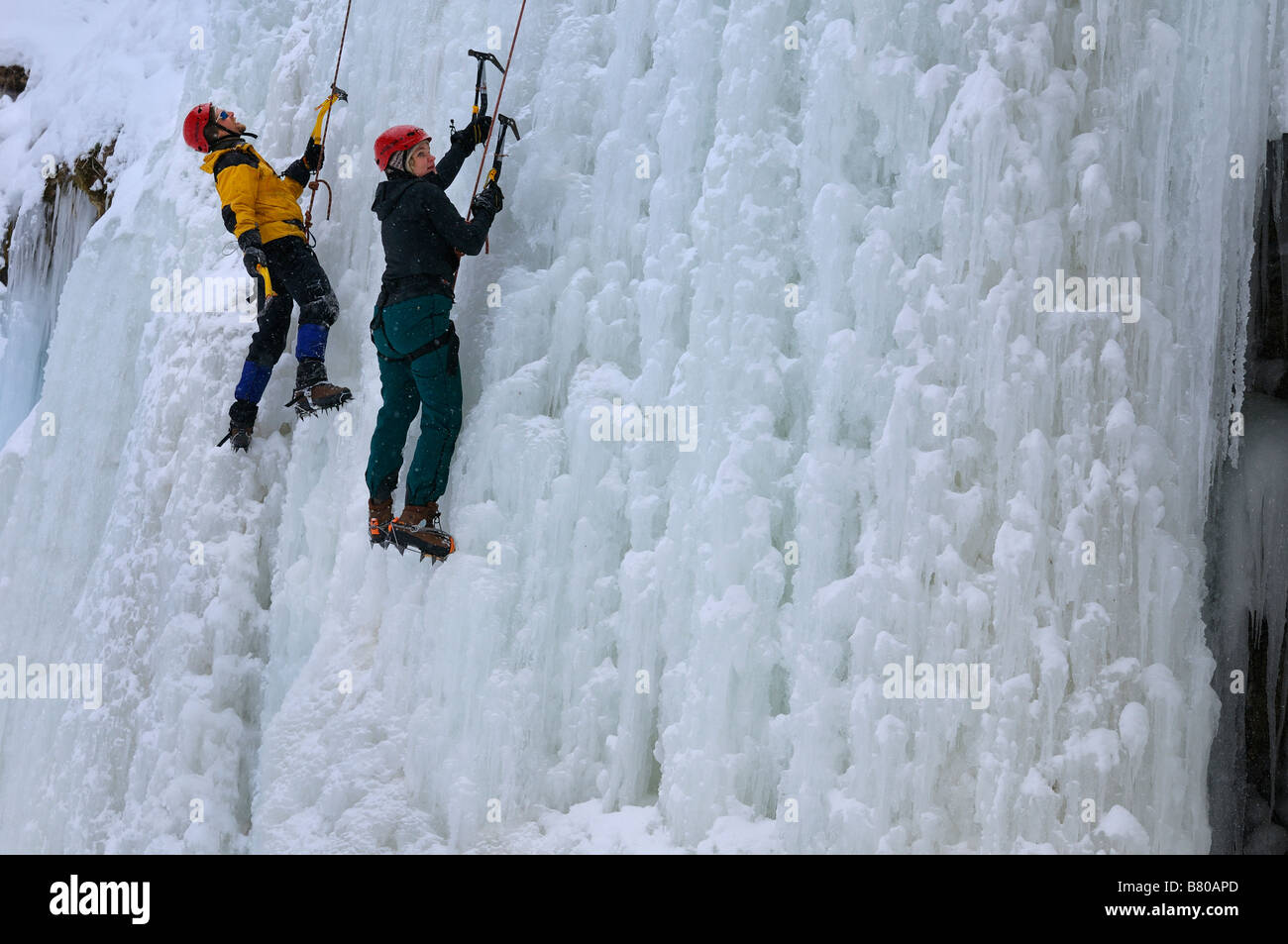 Zwei Eiskletterer anhalten für eine Rast auf einer Eiswand in Tiffany Falls Ontario Kanada Stockfoto