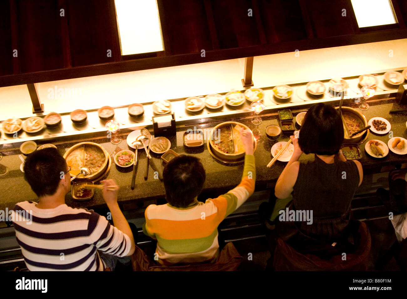 Platten-Zug in einem modernen Hotpot Restaurant in Chengdu in Sichuan in China. Stockfoto