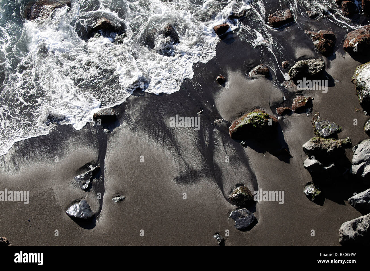 Meer wäscht einen schwarzen Sandstrand in Teneriffa Kanarische Inseln Stockfoto