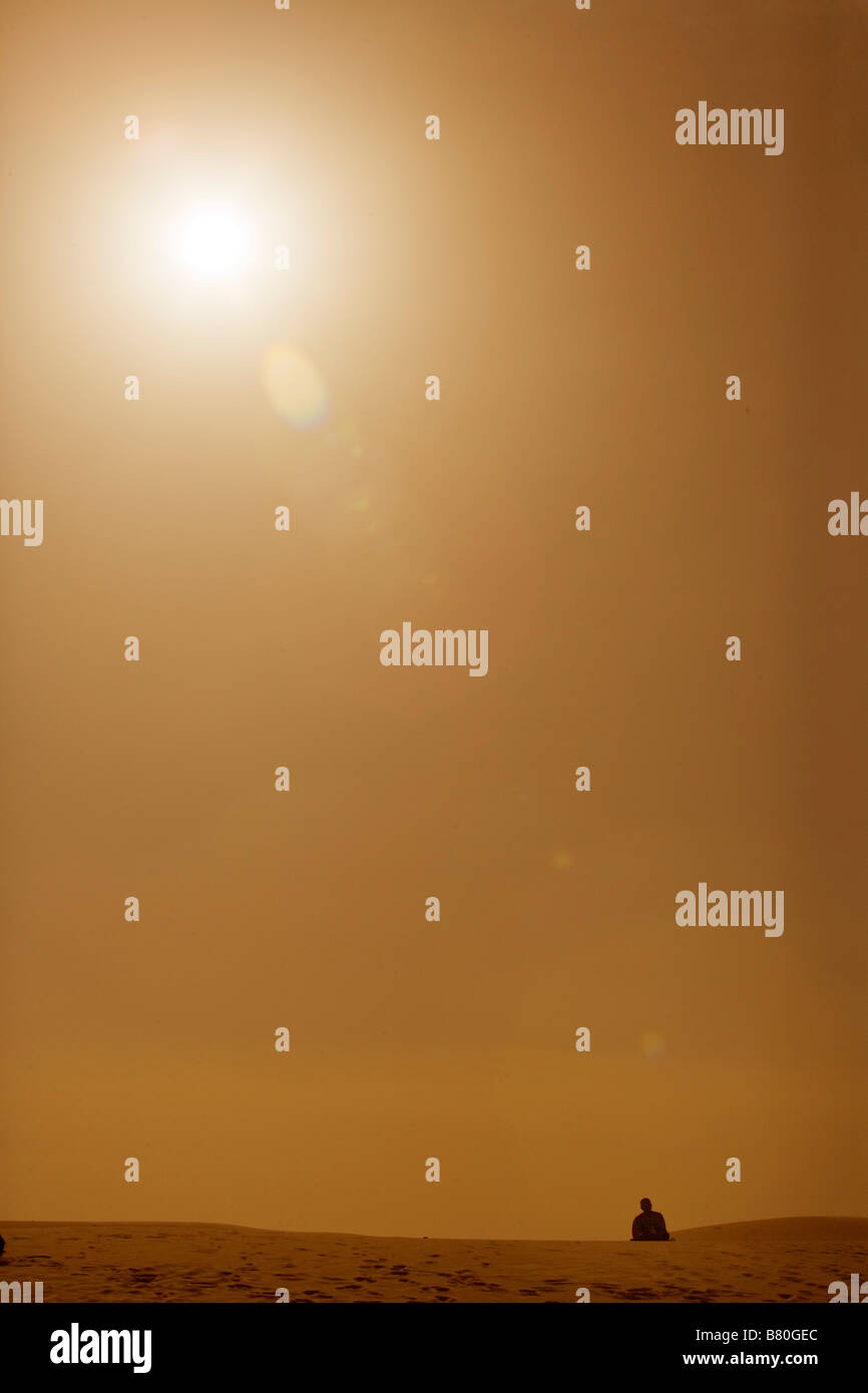Mann zu Fuß in Ferne auf Sanddüne. Stockfoto