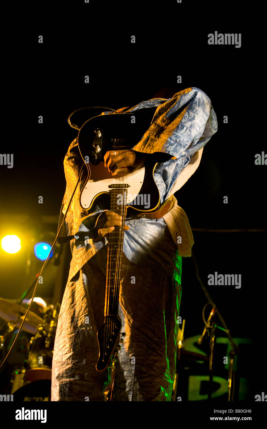 Afrikanische Musiker spielt die Gitarre hinter seinem Rücken. Stockfoto