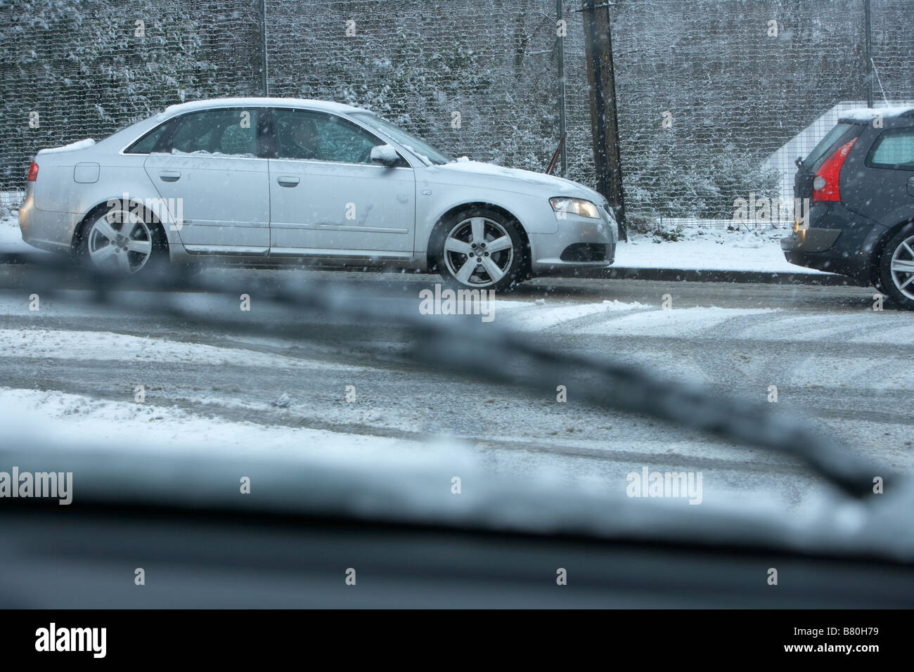 auf der Suche durch Auto Windschutzscheibe während Schneesturm am Schlange von Autos sitzen im verschneiten tückischen Fahrbedingungen auf einer Straße junct Stockfoto