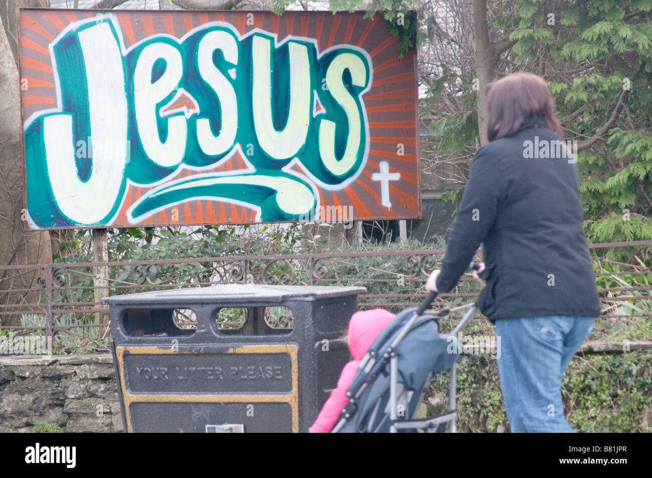 Eine Mutter und Tochter gehen vorbei an Jesus Zeichen Stockfoto