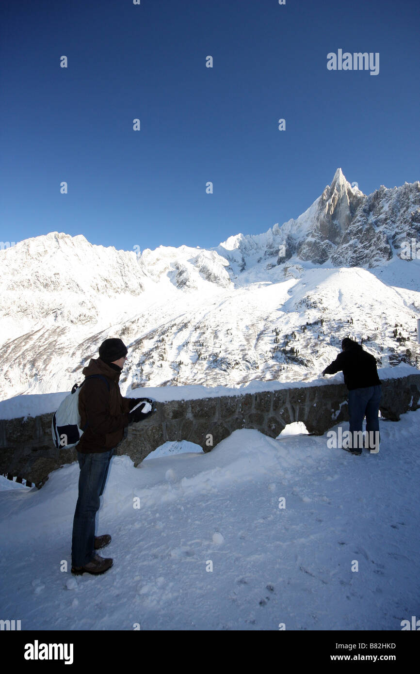 Zwei junge Männer werfen Schneebälle auf einander in den Alpen Stockfoto