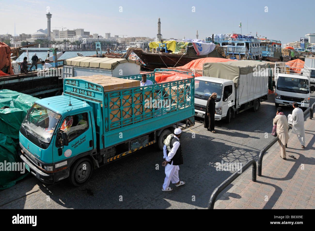 Dubai Creek Dhow & Fracht Waren auf verstopften Hafen Quayside LKW-LKW warten auf Be- oder Entladen Vereinigte Arabische Emirate VAE Naher Osten Stockfoto
