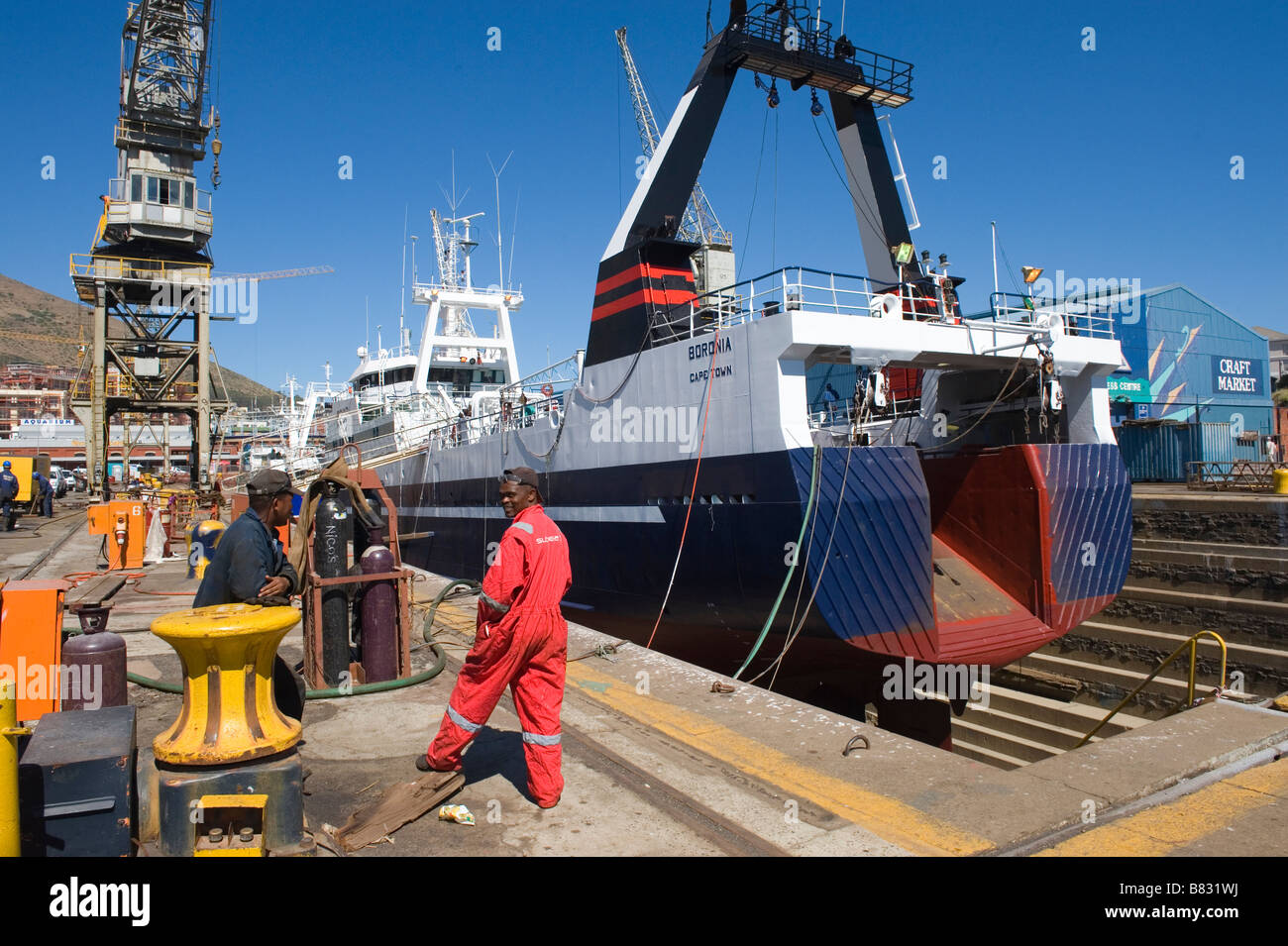 Arbeiter und ein Fisch-Trawler in einem trockenen dock in Cape Town, South Africa Stockfoto