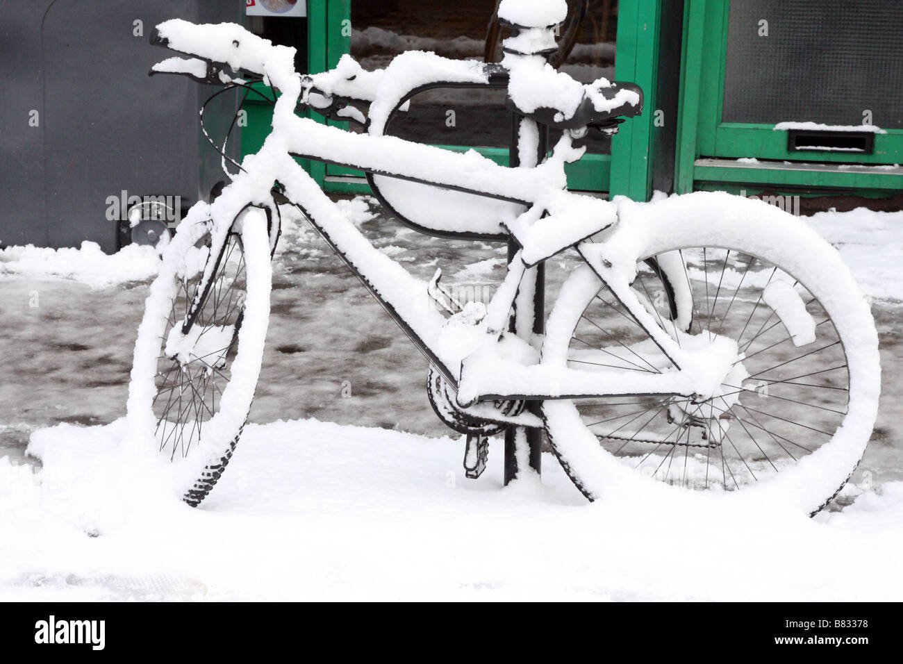 Dekorativ in einer frischen Schneeschicht bedeckt geparkte Fahrräder Stockfoto